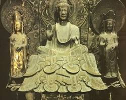 A bronze Shaka Triad sculpture from the Asuka period featuring a seated Buddha