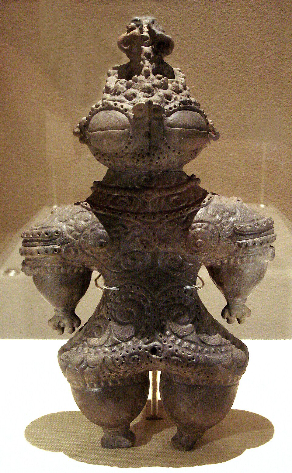 Ancient Japanese Shakoki-dogu clay figurine with characteristic oversized eyes and ornate geometric surface decorations