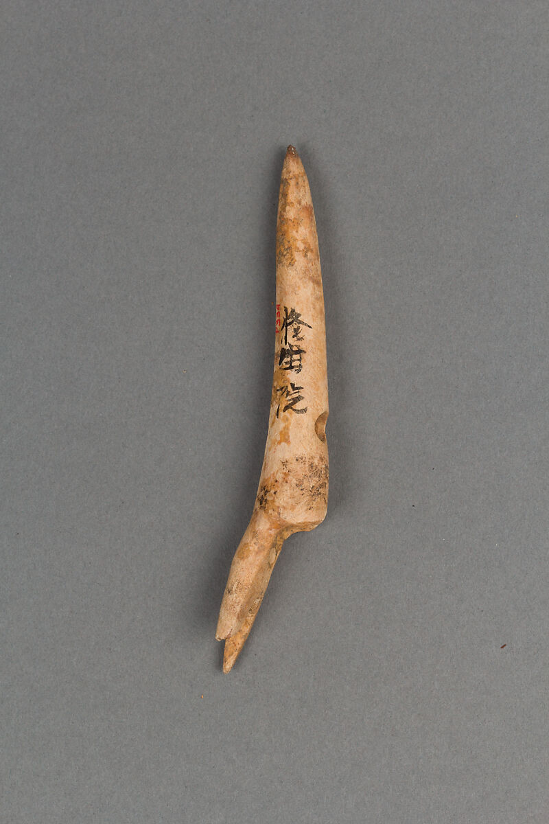 A carved bone toggle harpoon head from the Jōmon period, used for hunting fish and sea mammals