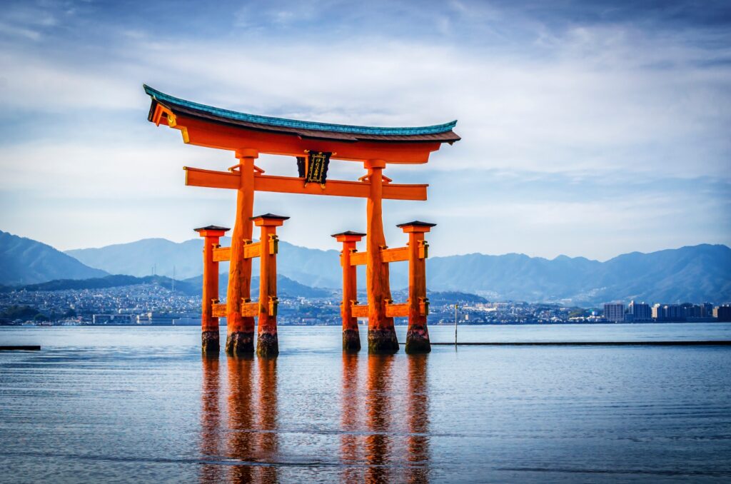 A bright red Torii gate surrounded by calm water.