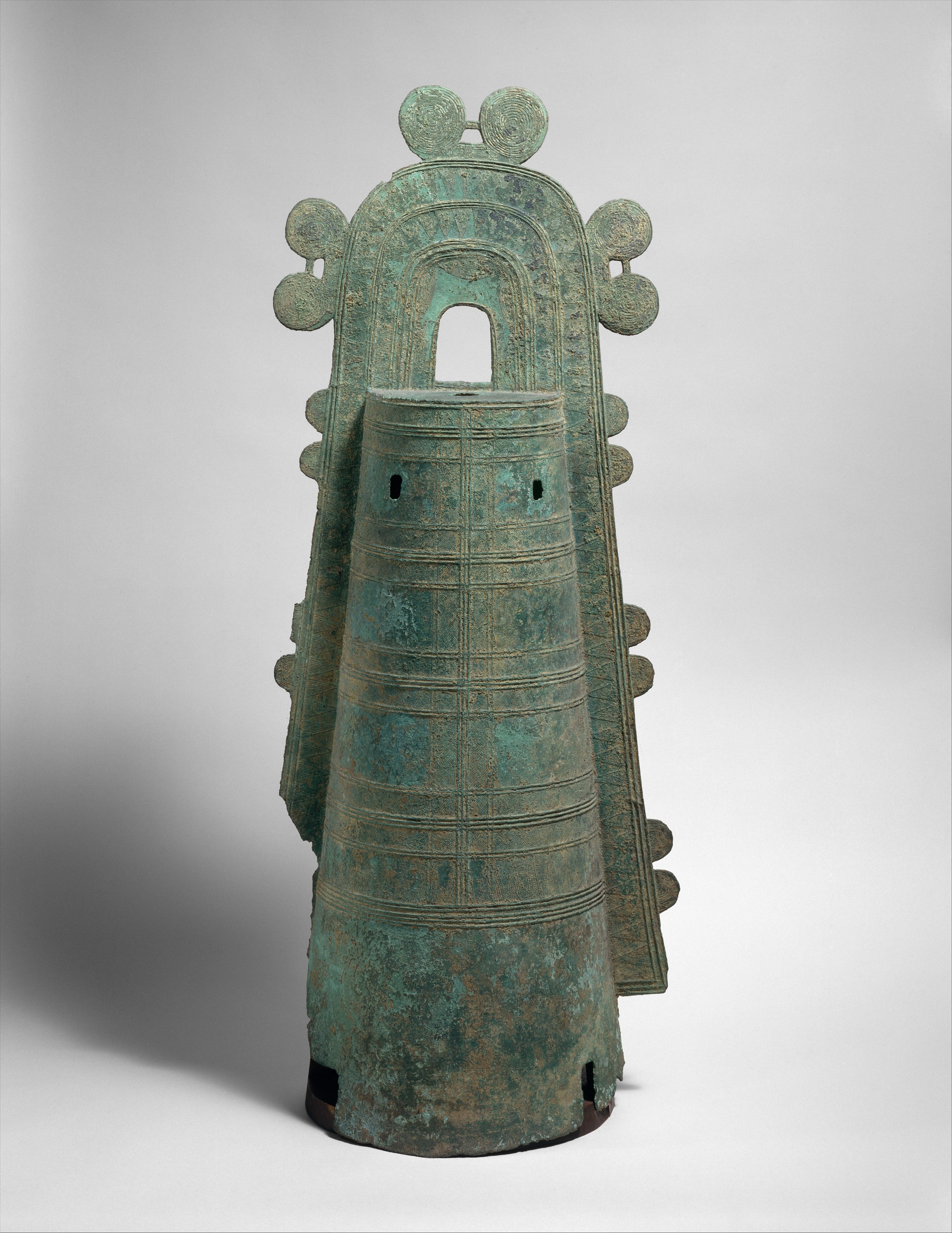 Ancient Japanese Dōtaku bronze ceremonial bell from the Yayoi period, featuring a tall, flared body, etched with decorative patterns and scenes of daily life