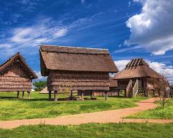 Reconstructed Yayoi period village at Yoshinogari featuring several thatched-roof pit dwellings and a raised-floor granary.