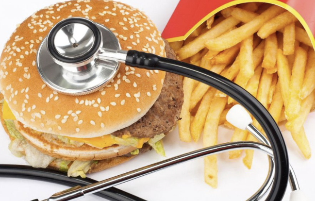 a burger and fries with a doctor tool on top