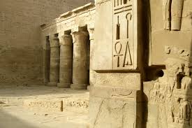 Ancient Egyptian temple wall covered in hieroglyphs and religious carvings